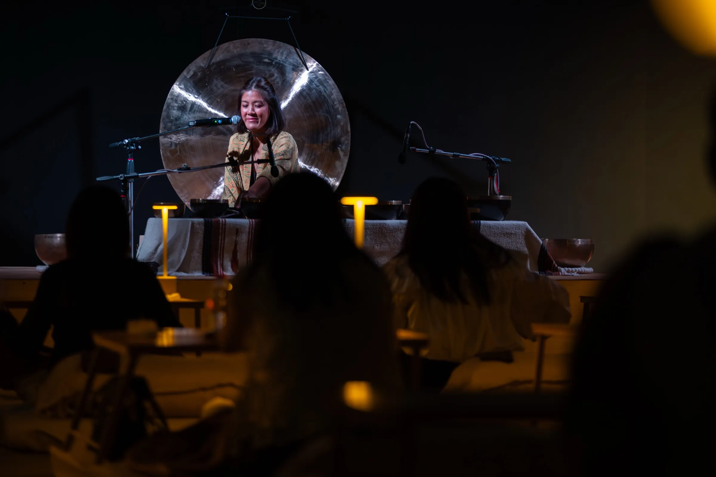 Ice performing a live sound bath on stage at a corporate event, audience seated in front.