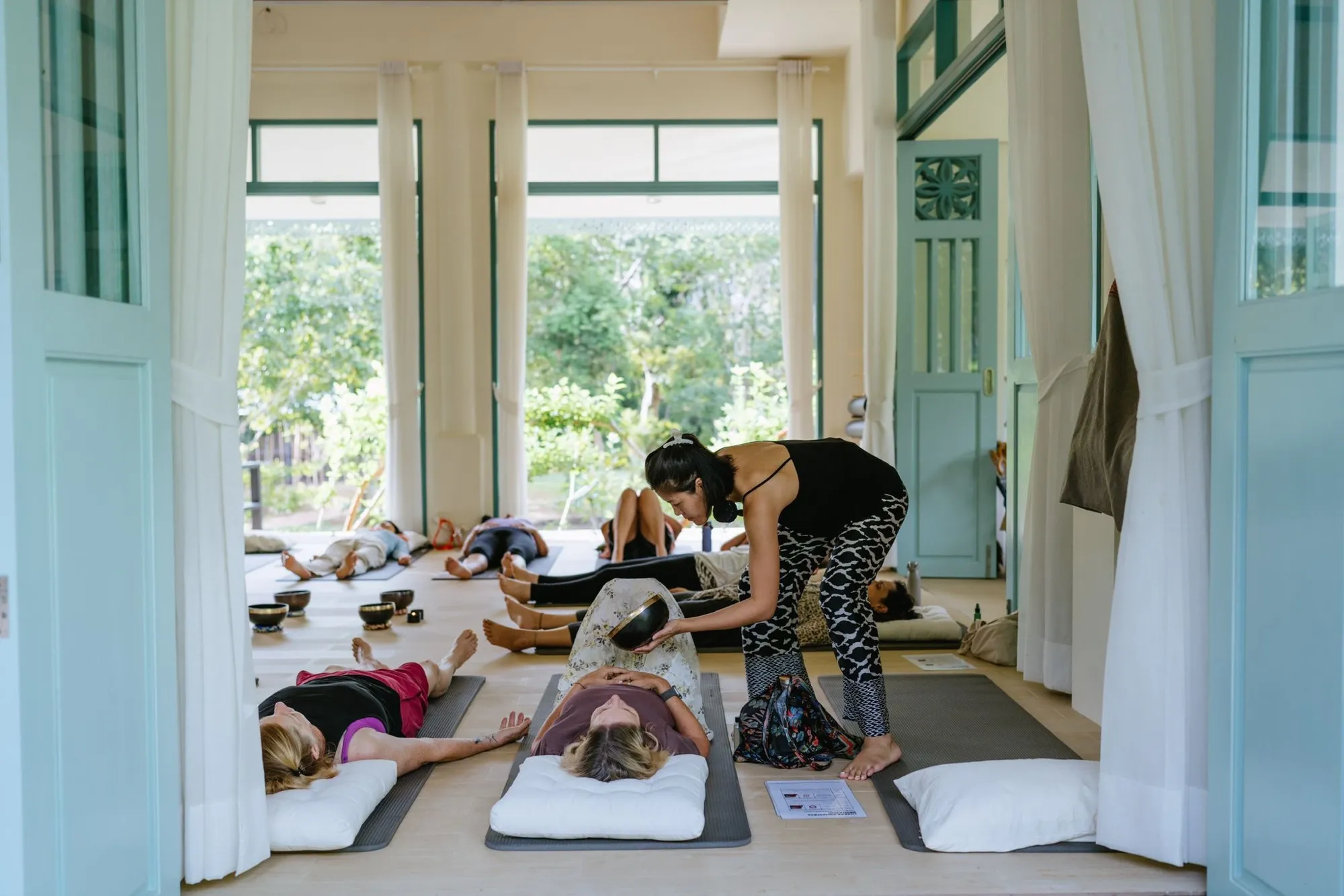 Ice giving a guest an individual singing bowl treatment during a retreat.