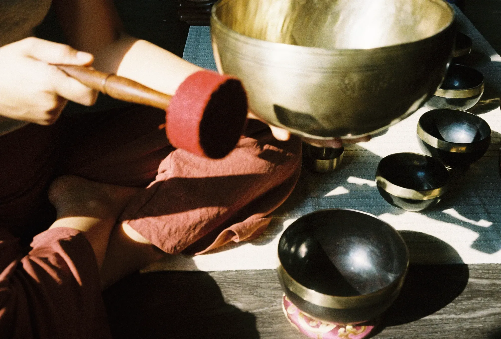 Playing a Himalayan singing bowl during a sound healing session.